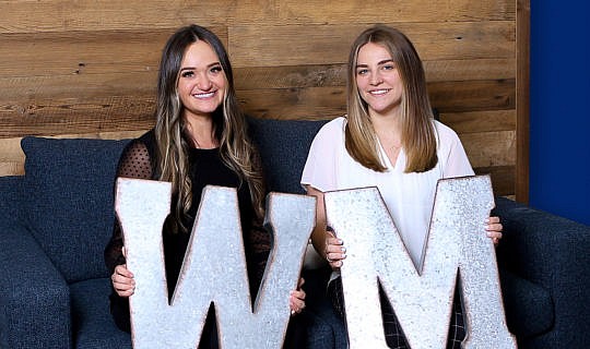 Whiteboard Marketing team members holding a giant W and M