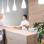 Woman receiving paperwork to fill out at front desk