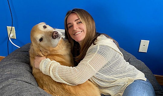 Whiteboard Marketing team member hugging a dog at work